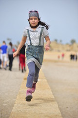 Young girl running on the beach of Caesarea