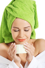 Woman in bathrobe with cream