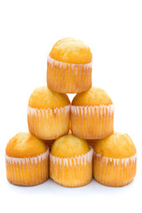 golden cup cakes stack up on a white background