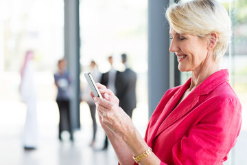 middle aged businesswoman reading email on smart phone