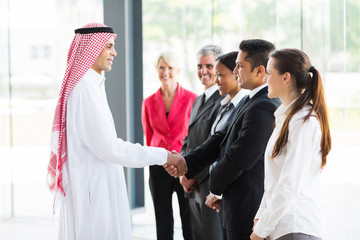 Arabian businessman handshaking with his employees