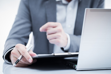 Businessman analyzing investment charts with laptop