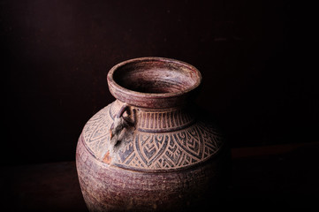 Earthenware jug standing on dark room