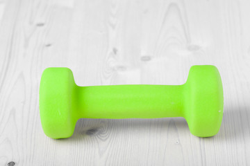 small green dumbbells on wooden surface