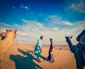 Two cameleers (camel drivers) with camels in dunes of Thar deser