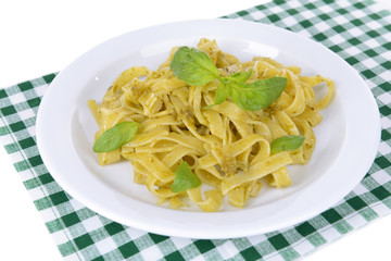 Delicious pasta with pesto on plate on table close-up