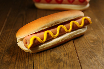 Tasty hot dogs on wooden table