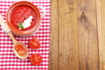Tasty tomato soup on wooden table
