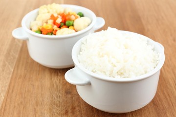 Cooked rice with vegetables on wooden table close up