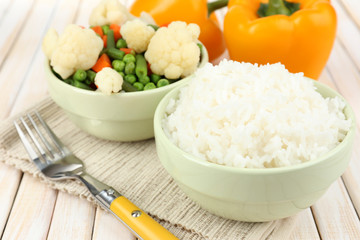 Cooked rice with vegetables on wooden table close up