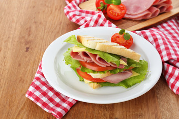 Tasty sandwich with ham on wooden table