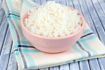 Cooked rice in bowl on wooden background