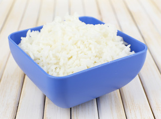 Cooked rice in bowl on wooden background