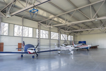 Three light airplanes stationed in an air dock
