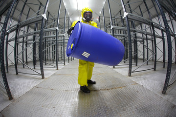 technician in protective  uniform with blue barrel