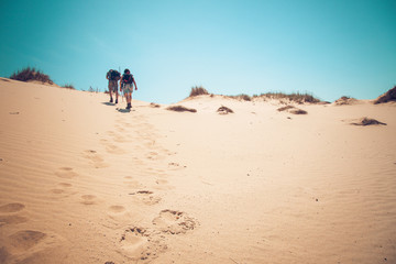 couple climbing sand dunes