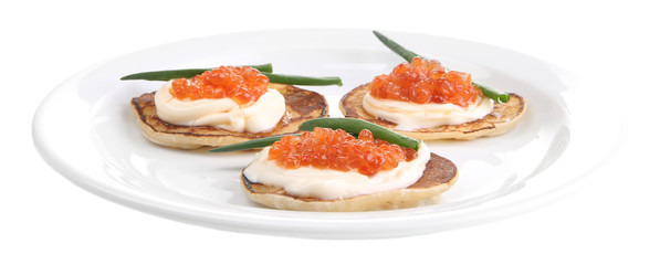 Pancakes with red caviar on plate, isolated on white