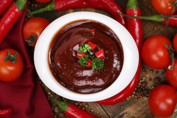 Tomato sauce in bowl on wooden table close-up