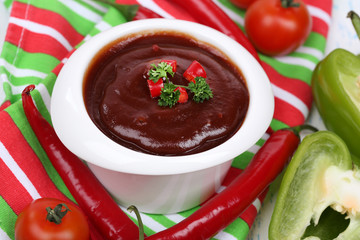 Tomato sauce in bowl on wooden table close-up
