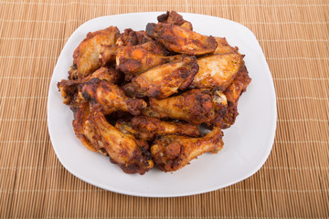 Mesquite Barbecue Chicken Wings on White Plate and Bamboo Mat