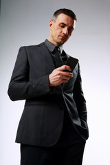 Businessman using smartphone over gray background