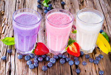 Fresh milk, strawberry, blueberry and banana drinks on wodeen 