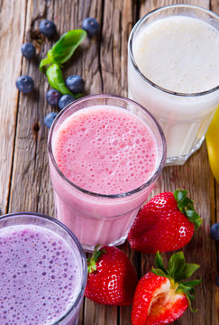 Fresh milk, strawberry, blueberry and banana drinks on wodeen 