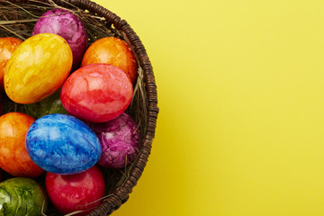 Ostereier im Korb vor gelbem Untergrund