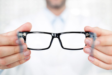 Closeup of optometrist, optician giving glasses