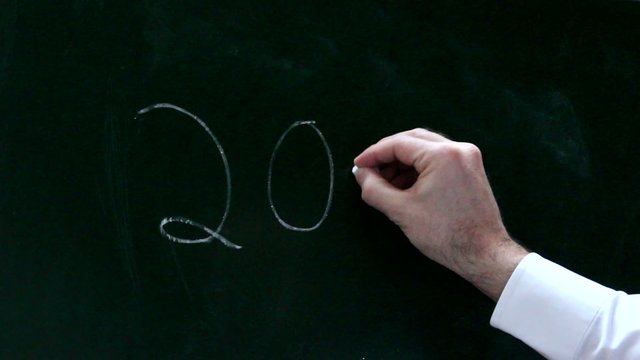 Eine M&auml;nnerhand schreibt 2017 auf eine Tafe
