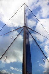 reflexions of clouds and blue sky in facade of modern building