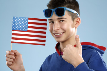 young smiling male student teenager holding a flag