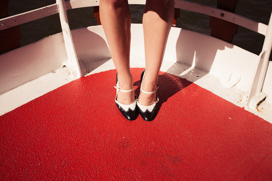Woman's feet and shoes on the deck of a ship