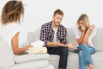 Man speaking to therapist at couples therapy while woman is