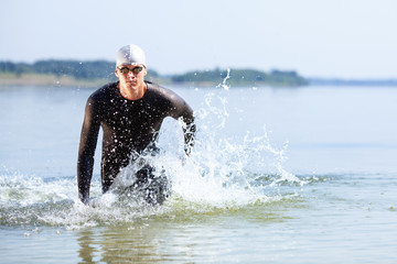 Triathlete running out of the water