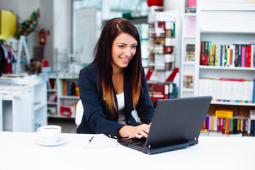 Student typing on laptop in library