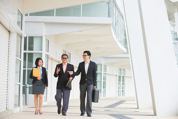 asian business team walking in office background