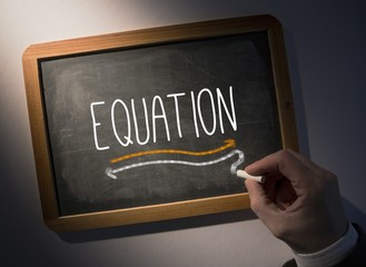 Hand writing Equation on chalkboard