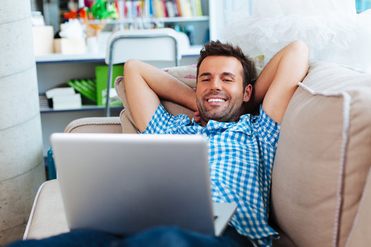 Man Relaxing With Laptop On Couch