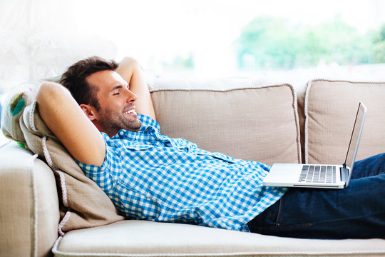 Man relaxing with laptop on couch