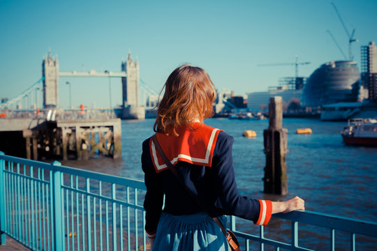 Young woman standing on the bank of the Thames in London