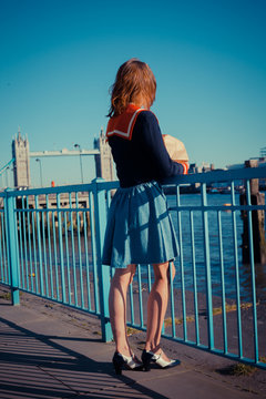 Young woman standing on the bank of the Thames in London