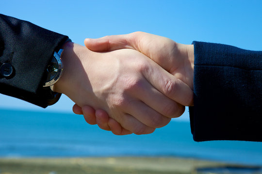 Handshake in front of the sea