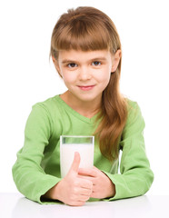 Happy little girl with a glass of milk