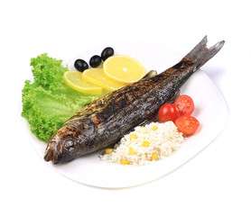 Grilled seabass on plate with vegetables.