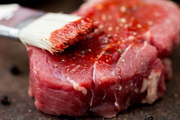 Raw beef steak, greased tomato sauce brush, cooking delicious