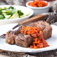 Grilled beef steak with salsa sauce dried tomatoes, red peppers