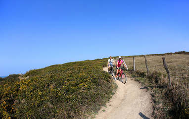 Obraz premium Couple riding bike on country path