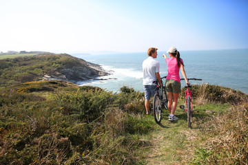 Couple on biking day stopping by coastline