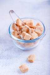 Brown cane sugar cubes in a glass bowl